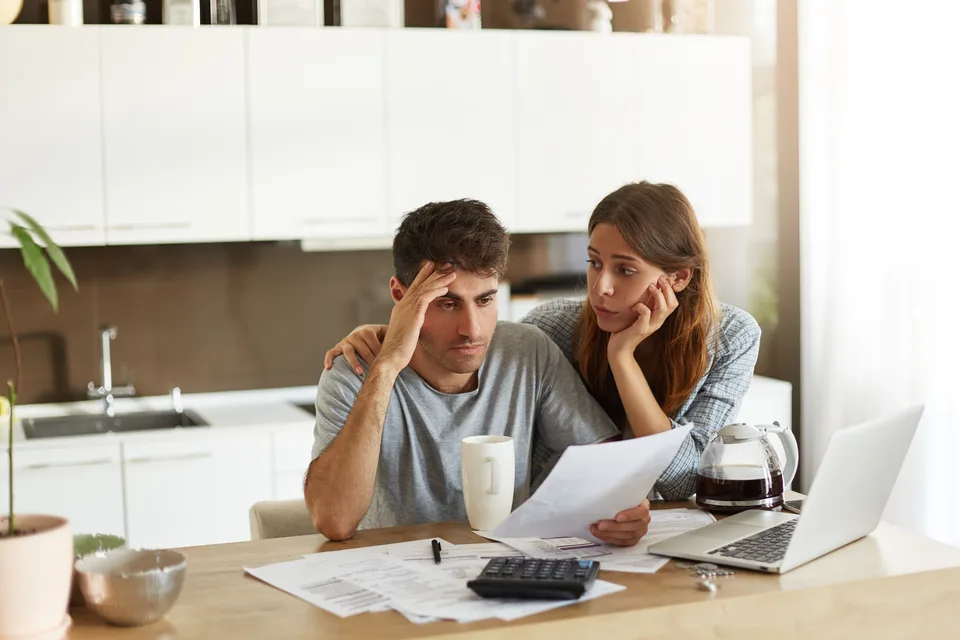 Pareja colombiana revisando su presupuesto familiar